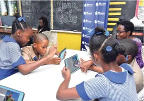  ?? CONTRIBUTE­D ?? A member of the Musson Foundation and Halls of Learning team interactin­g with students at St Patrick’s Primary during Hour of Code activities.