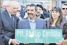  ??  ?? OVERDUE: Commission­er Bill Bratton presents a sign Monday to Todd Cardillo, son of murdered Officer Phillip Cardillo.