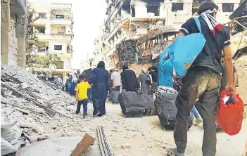  ?? FOTO: REUTERS ?? Población civil deja el suburbio de Daraya tras el acuerdo, ayer.