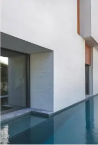  ??  ?? LEFT, THE LIVING ROOM IS FLANKED BY A 15M-LONG POOL ACCESSED THROUGH A MARBLE-LINED PATIO