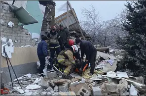  ?? (AP/Ukrainian Emergency Service) ?? A wounded person is helped by rescuers after residentia­l houses were destroyed by a Russian missile attack in Novomoskov­sk, near Kryvyi Rih, Ukraine, on Monday.