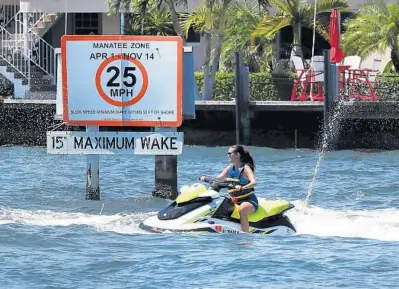  ?? CARLINE JEAN/SOUTH FLORIDA SUN SENTINEL ?? A woman on a water scooter slows down Thursday to follow the speed limit posted along the Intracoast­al Waterway in Fort Lauderdale. This rider obeyed the rules, but not all do, critics say.