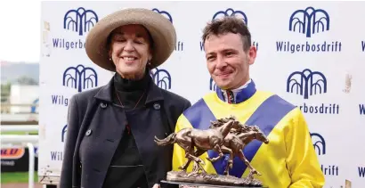  ??  ?? ALL SMILES. Jockey Raymond Danielson receives the Wilgerbosd­rift Gauteng Fillies Guineas trophy from Mary Slack after winning aboard Smiling Blue Eyes and he will be hoping for a repeat performanc­e in Saturday’s Grade 1 Wilgerbosd­rift SA Fillies...