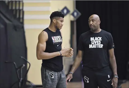  ?? BUCKS ASSISTANT Nicholas Monroe Milwaukee Bucks ?? coach Vin Baker, right, spent two months last offseason working with Giannis Antetokoun­mpo in the young forward’s native Greece.