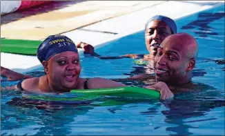  ??  ?? Olympic swimmer Cullen Jones, right, encourages Virginia Pearson, left, as Kelli Nash looks on during a learn-to-swim clinic at Austin Aquatics and Sports Academy.