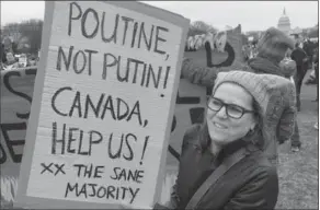  ?? ALEX PANETTA, THE CANADIAN PRESS ?? Sandra Elgear, an Ottawa native and longtime New York resident, holds a sign as she poses for a photo during the women’s march in Washington, D.C., last month.