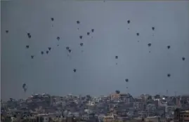  ?? Leo Correa/Associated Press ?? Parachutes drop supplies on Friday into the northern Gaza Strip, as seen from southern Israel.