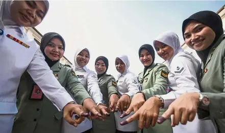  ?? — Bernama ?? Done it: Members of the armed forces showing their ink-stained forefinger after casting their votes.