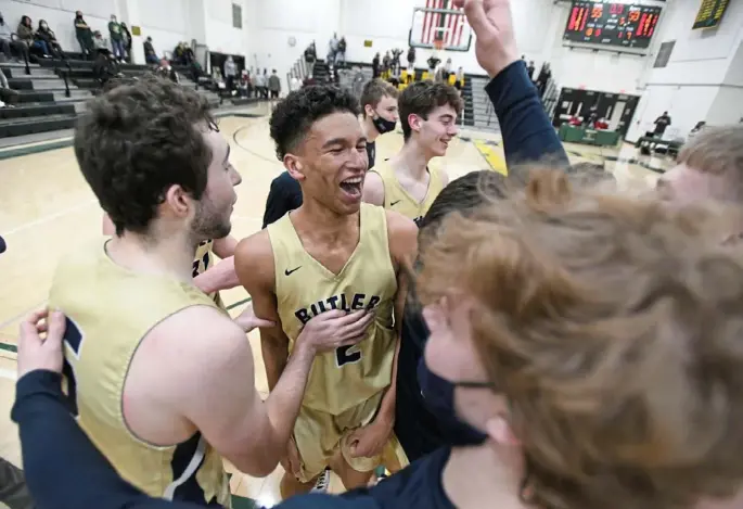  ??  ?? Devin Carney celebrates with his teammates after his 3-pointer at the buzzer lifted Butler to a 58-55 win over Penn-Trafford in the WPIAL Class 6A quarterfin­als.