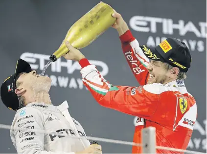  ?? Picture: EPA ?? VICTORY DRINK: New Formula One world champion Nico Rosberg, left, celebrates with Ferrari driver Sebastian Vettel