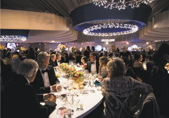  ?? Photos by Laura Morton / Special to The Chronicle ?? Symphony-goers sit down to dinner in a glamorous tent constructe­d outside Davies Symphony Hall for the San Francisco Symphony’s Opening Night Gala.