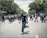  ?? Picture: AFP ?? UNDER SIEGE: Congolese protesters scatter as police open fire with rubber bullets during a protest against President Joseph Kabila outside the Democratic Republic of Congo’s embassy in Pretoria on Tuesday