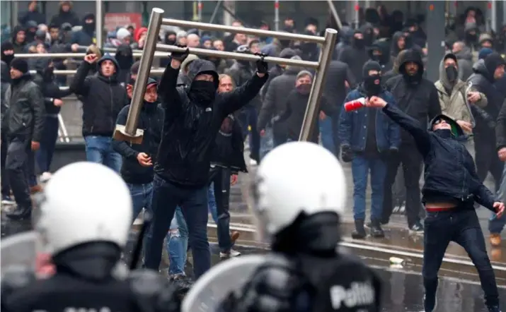  ?? FOTO REUTERS ?? Honderden hooligans en amokmakers dagen de politie uit en smijten met alles wat los of halflos staat.