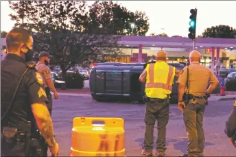  ?? JOHN MILLER/Taos News ?? Jason Rael, a sergeant at the Taos County Sheriff’s Office, takes photos of a truck that was rear-ended by a Taos County Sheriff’s deputy Thursday night (July 9) after its driver attempted to pull back into the northbound turn lane of Paseo del Pueblo Sur at Siler Road. The driver said he didn’t see the deputy coming.