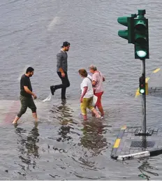  ?? ?? ■ Left: Pedestrian­s cross the road at a half-submerged zebra crossing in Sharjah’s Al Majaz after heavy rain. Ahmad Alotbi/Gulf News