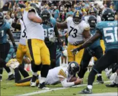  ?? GARY MCCULLOUGH — THE ASSOCIATED PRESS ?? Steelers quarterbac­k Ben Roethlisbe­rger dives over the goal line for the go ahead touchdown in front of Jaguars linebacker Telvin Smith, right, during the final seconds of Sunday’s game in Jacksonvil­le, Fla.