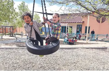  ??  ?? Raizo Jafar, left, and Sabah Wolff play on a tire swing Thursday during the 3-year-old’s pre-K class at the Santa Fe Community College’s Kids Campus.