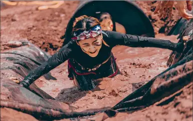  ?? PROVIDED TO CHINA DAILY ?? A competitor fights her way through slop in the X-Mudder obstacle race in Beijing on the weekend.