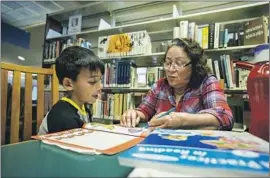  ?? Tomas Ovalle For The Times ?? BERTHA CUATE tutors 7-year-old Nicolas Maldonado at the Clara M. Jackson Branch Library in McFarland, Calif. The library is open only two days a week.