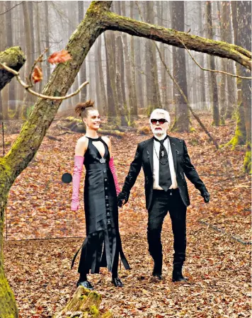  ??  ?? Karl Lagerfeld acknowledg­es the applause of the audience on his forest catwalk at the end of the Chanel show