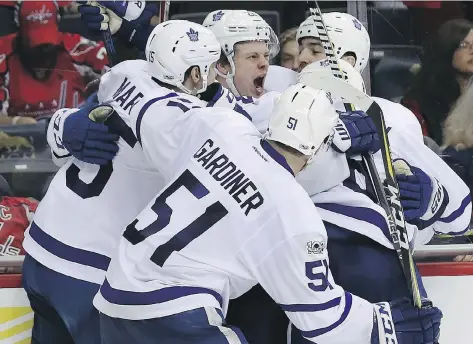  ?? ROB CARR/GETTY IMAGES ?? Toronto Maple Leafs teammates embrace forward Kasperi Kapanen after his game-winning goal against the Washington Capitals in double overtime on Saturday in Washington, D.C. The 4-3 Leafs victory evened the series at 1-1, with Game 3 on Monday in Toronto.