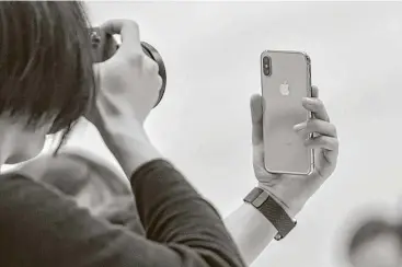  ?? David Paul Morris / Bloomberg ?? A photo is taken of an Apple iPhone X during its preview Tuesday at the Steve Jobs Theater in Cupertino, Calif. The iPhone X — pronounced like the number 10 — will have a screen with higher resolution.