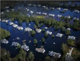  ?? KRISTEN ZEIS—THE ASSOCIATED PRESS ?? Dozens of homes are surrounded by floodwater­s brought to the area by Hurricane Florence in Pender County, N.C. The floodwater­s have swallowed an estimated 25 percent of Pender county.