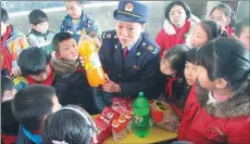  ?? LI JIANPING / FOR CHINA DAILY ?? A quality supervisio­n official in Ji’an, Jiangxi province, teaches local students how to distinguis­h counterfei­t food and drinks.