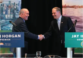  ?? CP PHOTO ?? British Columbia Premier John Horgan shakes hands with Washington Gov. Jay Inslee following a joint news conference on Thursday in Seattle.