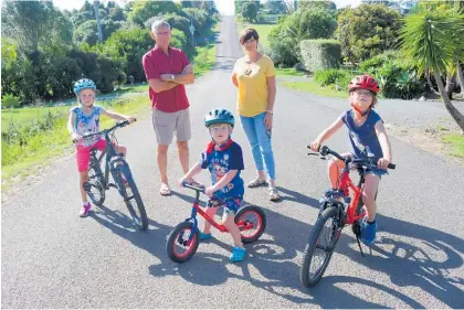  ?? Photo / Peter de Graaf ?? Hall Rd residents David Clendon and Beth Clarke, with Bronte Clarke, 6, Mac Clarke, 3, and Darcy Clarke, 6, want safety improvemen­ts to the road before constructi­on of a major new retirement village goes ahead.