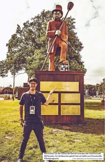  ??  ?? Bernd Dicks vor der Statue des fiktiven Gründers der Festival-Stadt, Bill Parooka. Für die Besucher gehört hier ein Selfie zum Parookavil­lePflichtp­rogramm.