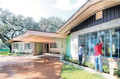  ?? JOE BURBANK/ORLANDO SENTINEL ?? Men clean windows on the front of the mid-century modern estate of famed entreprene­ur Jeno Paulucci in Sanford on Wednesday.