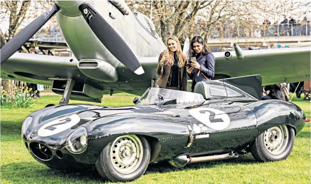  ??  ?? Sonia Del Rosario, left, and Radhika Sharma, from London, admire a Jaguar D-Type in front of a Vickers Supermarin­e Silver Spitfire Mk IX at the 77th Goodwood Members’ Meeting in West Sussex. The event is a weekend of motor racing that aims to recreate the atmosphere of the original BARC Members’ Meetings held at Goodwood throughout the Fifties and Sixties.