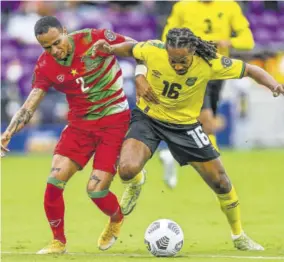  ?? ?? Jamaica’s Daniel Johnson (right) and Suriname’s Damil Dankerlui fight for the ball during the Gold Cup football match at the Exploria Stadium in Orlando, Florida, on July 12, 2021.