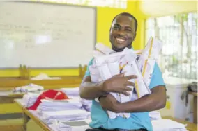  ?? (Photos: Ryan Mattis) ?? A bright smile from Little Bay Infant and All-age School Principal Keron King as he prepares to deliver schoolwork to students.