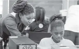  ?? PETER ANDREW BOSCH Miami Herald file ?? Willae Ivory, who works with Black Girls CODE, helps Honesty King with her web design in a workshop in 2013. Miami-based workers and students with a STEM background are guaranteed at least two dozen slots in an upcoming different program.