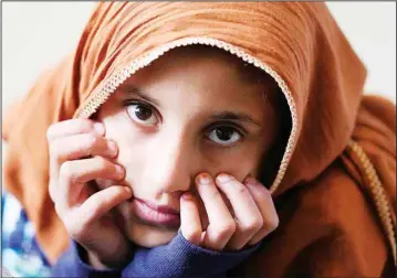  ??  ?? A girl from Afghanista­n waits with other evacuees to fly to the United States or another safe location in a makeshift departure gate inside a hangar at the U.S. Air Base in Ramstein, Germany, Sept 1. The United States is using the military base in Ramstein as a hub for the evacuation of shelter seekers and local forces from Afghanista­n. (AP)