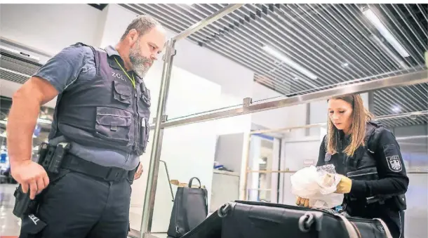  ?? FOTOS (2): ANDREAS BRETZ ?? Marcel Spreyer und Sarah Kröger kontrollie­ren am Düsseldorf­er Flughafen einen Koffer.