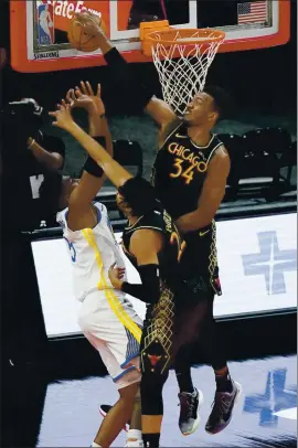  ?? NAM Y. HUH — THE ASSOCIATED PRESS ?? Bulls center Wendell Carter Jr., right, blocks a shot by Warriors forward Kevon Looney during the first half in Chicago on Sunday night.