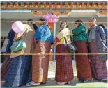  ?? – AFP ?? THIMPHU, Bhutan: Women wait in a queue to cast their votes outside a polling station in Thimphu on Jan 9, 2024.