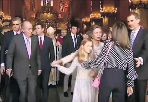  ?? TWITTER ?? King Juan Carlos I, at left, looks on as Queen Letizia (back to camera) appears to tussle with former Queen Sofia, who was trying to pose for a photo with Princess Leonor (in white dress, left) and Princess Sofia (obscured) as King Felipe VI of Spain...
