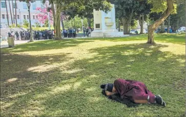  ?? Irfan Khan
Los Angeles Times ?? A HOMELESS PERSON sleeps on the lawn of City Hall as Los Angeles elected officials announce at a news conference a plan to declare an emergency on homelessne­ss and commit $100 million to the problem.