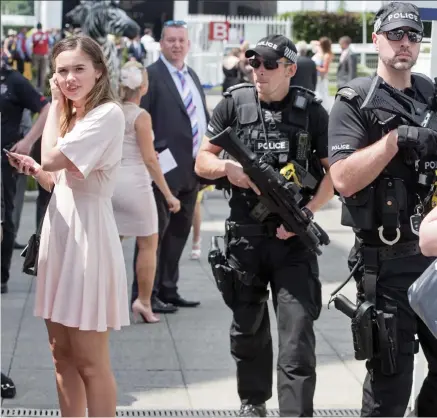  ??  ?? Heightened security: Firearms officers keep a careful eye on the public during Ladies Day