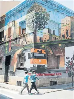  ?? JORDI ROVIRALTA ?? Dos chicas pasan junto al espectacul­ar mural, inaugurado ayer