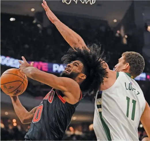  ?? MORRY GASH/AP ?? Rookie guard Coby White, who set a three-point record two nights earlier, tries to shoot past the Bucks’ Brook Lopez in the Bulls’ loss in Milwaukee.