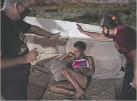  ??  ?? Members of the church pray for a woman in a “cracolandi­a” amid the covid-19 pandemic in Rio de Janeiro.