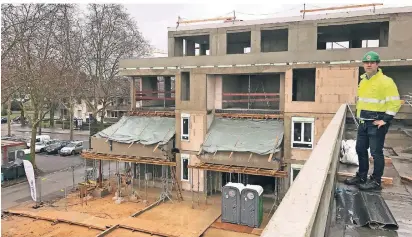  ??  ?? Bauleiter Bernd Wirtz auf der umlaufende­n Terrasse zu den beiden oberen Wohnungen: Von dort sieht man die vordere Haushälfte, und den Innenhof an der Straße. Er soll zum Treffpunkt für alle Nachbarn werden.