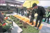  ?? SONG NING / FOR CHINA DAILY ?? The ashes of six people, in degradable urns, are placed into holes for burial during a group green funeral at the Yinlongsha­n Cemetery in Nanjing, Jiangsu province, last week.