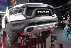  ?? Foto: Boris Rössler, dpa ?? So mögen es die Amerikaner: Wuchtige Pick ups, spektakulä­r in Szene gesetzt. Der Dodge Ram gehört zu den Stars der Messe in Detroit.