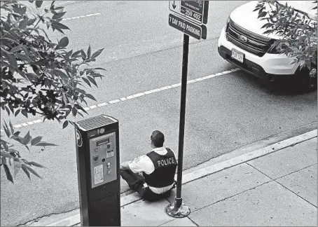  ?? MATT TUTEUR/FOR THE CHICAGO TRIBUNE ?? A Chicago police officer takes a moment after a police sergeant was found unresponsi­ve in his squad car on Sept. 3. His death was ruled a suicide.